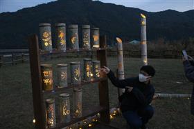制作した竹灯籠と記念撮影をする生徒