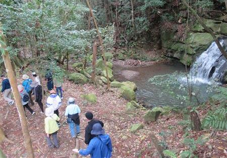 滝のほとりを歩く参加者