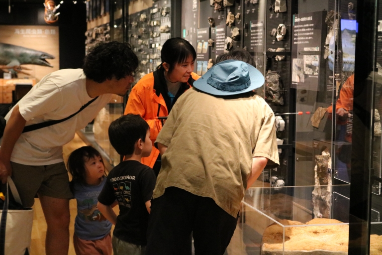 学芸員による展示物の解説を聞く参加者の画像