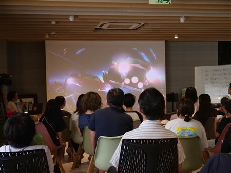 これまでの作品のショートムービーを視聴する参加者