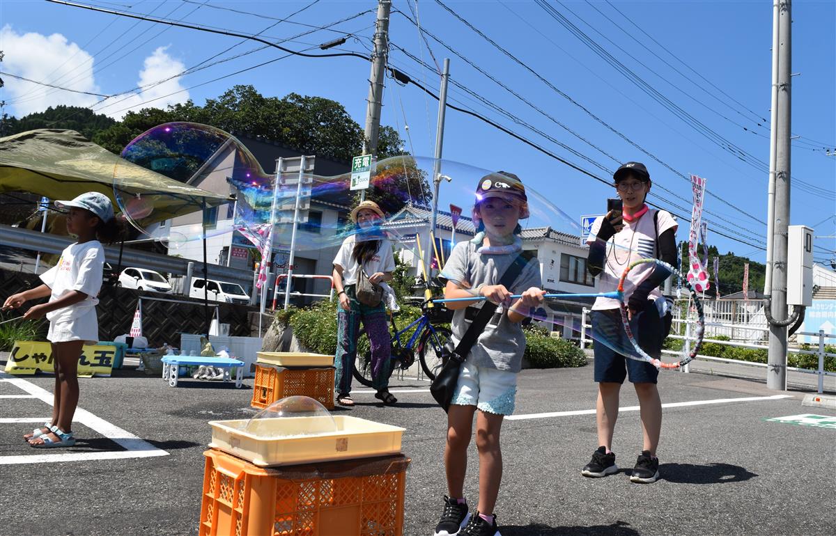 大きなシャボン玉をつくる子どもの画像